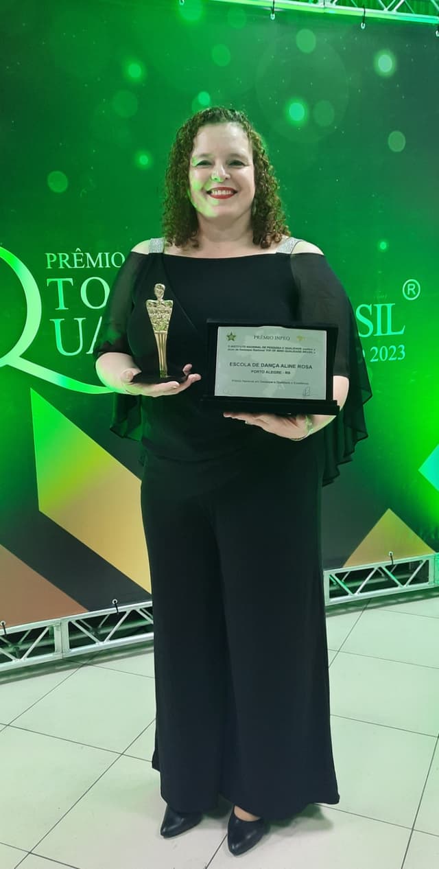 Aline Rosa, diretora da escola, recebendo o Prêmio Top of Mind Qualidade Brasil